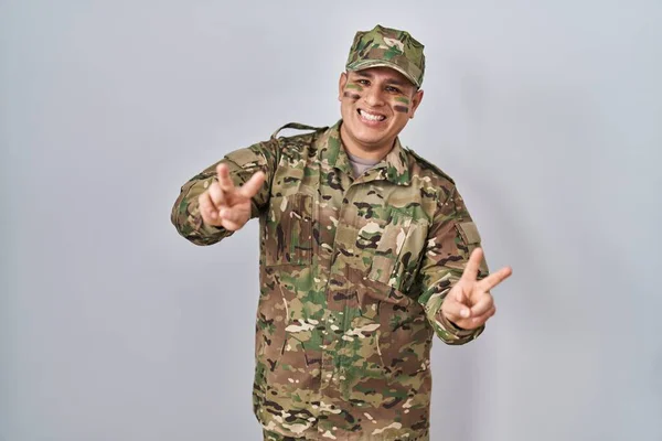 Латиноамериканец Камуфляжной Армейской Униформе Улыбается Глядя Камеру Показывая Пальцы Делающие — стоковое фото