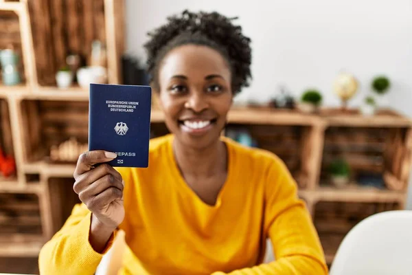 African American Woman Holding Deutchland Passport Sitting Table Home —  Fotos de Stock