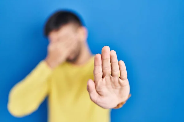 Hispanic Man Standing Blue Background Covering Eyes Hands Doing Stop — Fotografia de Stock