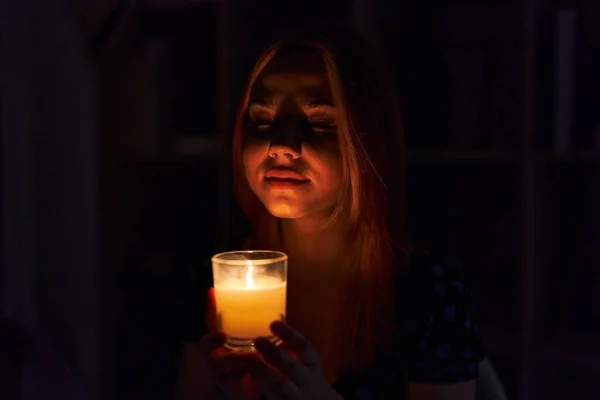 Νεαρή Καυκάσια Γυναίκα Κάθεται Στο Τραπέζι Μυρίζοντας Αρωματικό Κερί Στο — Φωτογραφία Αρχείου