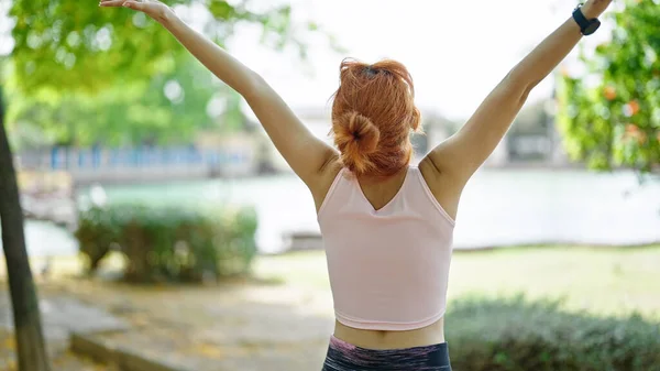 Genç Kızıl Saçlı Kadın Spor Kıyafetleri Giyiyor Parkta Kollarını Esnetiyor — Stok fotoğraf