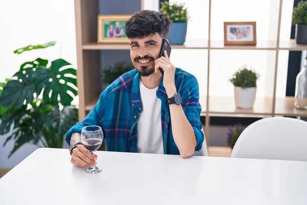Young Hispanic Man Talking Smartphone Drinking Wine Home — Stockfoto