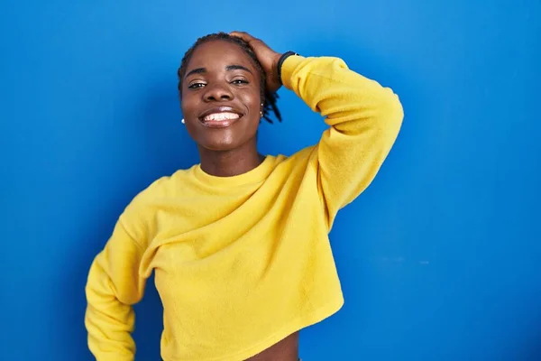 Mulher Negra Bonita Sobre Fundo Azul Sorrindo Confiante Tocando Cabelo — Fotografia de Stock