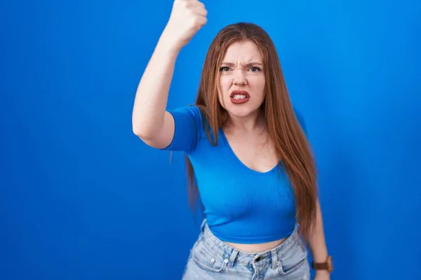 Κοκκινομάλλα Γυναίκα Στέκεται Πάνω Από Μπλε Φόντο Θυμωμένος Και Τρελός — Φωτογραφία Αρχείου