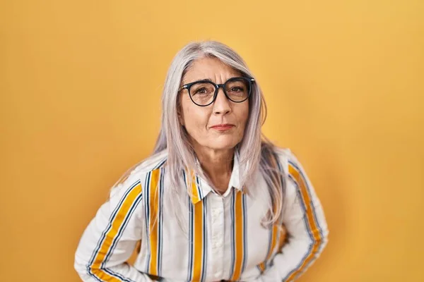 消化不良 痛みを伴う病気が体調不良のため 胃の上に手で眼鏡をかけて黄色の背景に立って白髪の中年女性 キャッシュ コンセプト — ストック写真