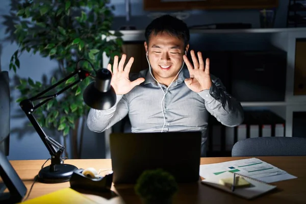 Молодой Китаец Работающий Ноутбуком Ночью Показывает Показывает Пальцами Номер Девять — стоковое фото