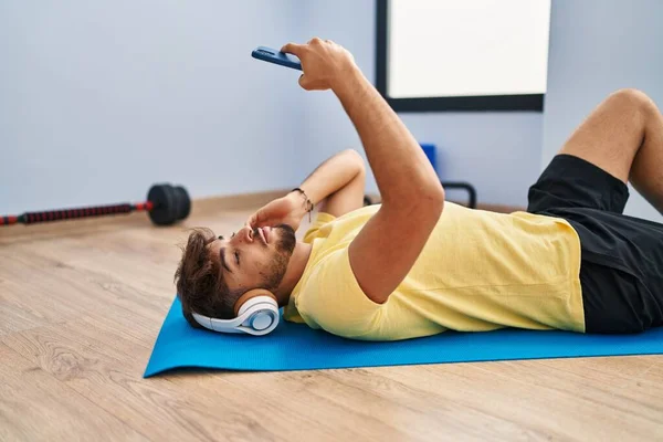 Young Arab Man Listening Music Lying Yoga Mat Sport Center — Stockfoto