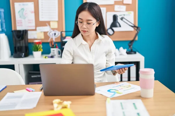 若い中国の女性のビジネス労働者がオフィスでタッチパッドとラップトップを使用して — ストック写真