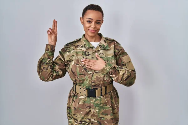 胸と指で手で手で身に着けているカモフラージュ軍の制服笑顔を身に着けている美しいアフリカ系アメリカ人女性 忠誠の誓いを作る — ストック写真