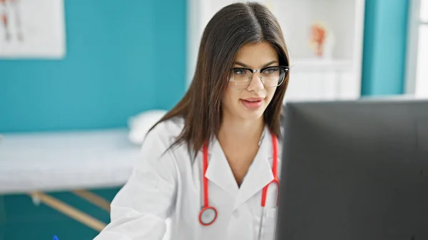 年轻的高加索女医生在诊所使用笔记本电脑 工作时表情轻松 — 图库照片