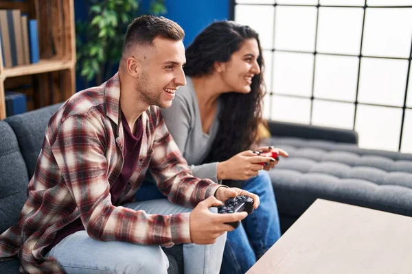 男人和女人坐在家里沙发上玩电子游戏 — 图库照片