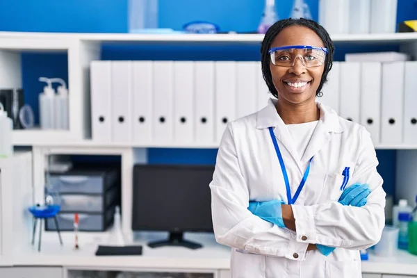 科学者の制服を着たアフリカ系アメリカ人女性が腕を組んでジェスチャー研究室 — ストック写真