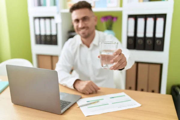 オフィスで水のノートパソコンを保持ガラスを使用して若いヒスパニック系の男のビジネスワーカー — ストック写真