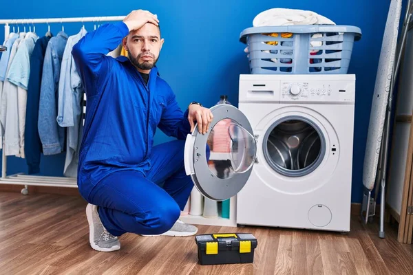 洗濯機に取り組んでヒスパニック系の修理工は強調し 頭の上に手で不満 驚きと怒っている顔 — ストック写真