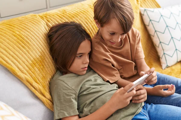 Akıllı Telefondan Video Izleyen Sevimli Çocuklar Evdeki Kanepede Oturuyorlar — Stok fotoğraf