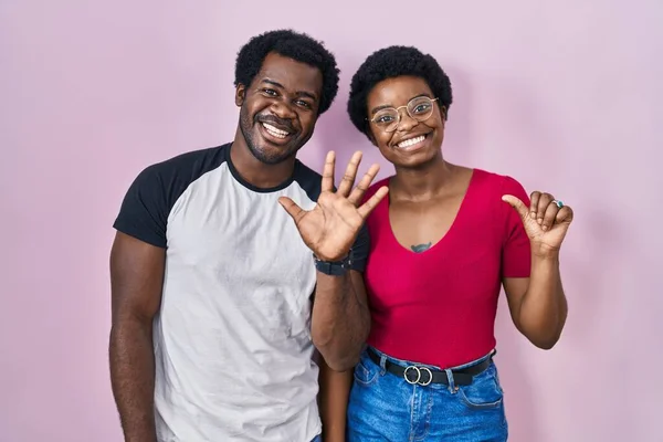 Молодая Африканская Американская Пара Стоит Розовом Фоне Показывает Пальцами Номер — стоковое фото