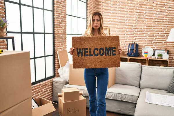 Young Blonde Woman Holding Welcome Doormat New Home Depressed Worry — Stock Photo, Image