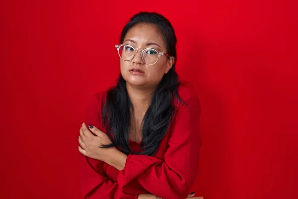 Asiatisk Ung Kvinna Står Över Röd Bakgrund Skakar Och Fryser — Stockfoto