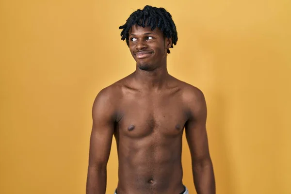 Młody Afrykanin Dredami Stojący Bez Koszuli Uśmiechnięty Patrząc Bok Patrząc — Zdjęcie stockowe