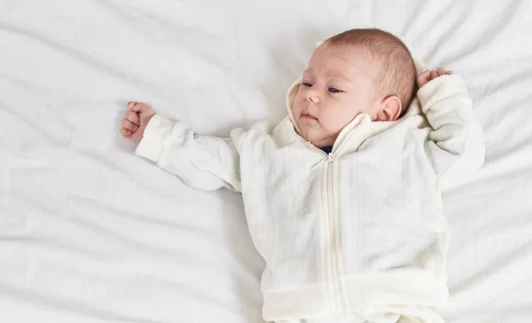 Sevimli Beyaz Bebek Yatak Odasında Gevşek Bir Ifadeyle Yatakta Yatıyor — Stok fotoğraf