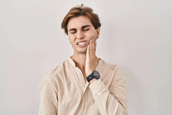 歯の痛みや歯の病気のために痛みを伴う表現で手で手に触れる孤立した背景に立っている若い男 歯科医 — ストック写真