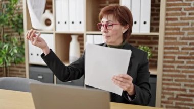 Olgun İspanyol kadın iş adamı. Ofise kağıt atmayı kutluyor.