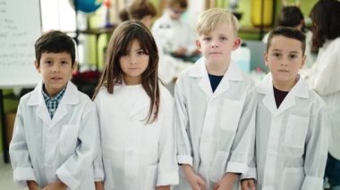 Bir grup bilim adamı öğrenci laboratuvar sınıfında kollarını kavuşturup sırıtarak gülümsüyor.