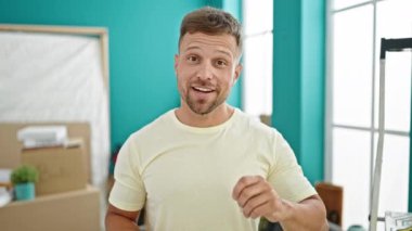 Elinde yeni evin anahtarları olan genç adam yeni evinde konuşuyor.