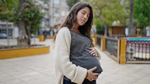 Молодая Беременная Женщина Улыбается Уверенно Касаясь Живота Парке — стоковое видео