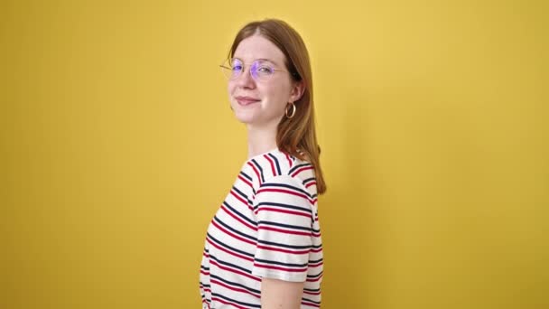 Młoda Blondynka Uśmiecha Się Pewnie Wskazując Kamerę Odizolowanym Żółtym Tle — Wideo stockowe