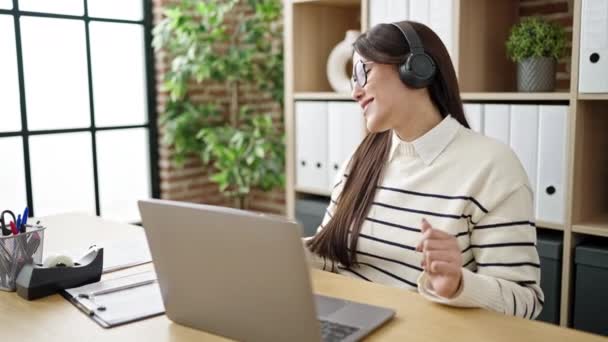 若い美しいヒスパニック系女性のビジネスワーカーは オフィスでコーヒーを飲む音楽を聞いて — ストック動画