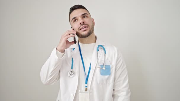 Joven Médico Hispano Sonriendo Confiado Hablando Smartphone Sobre Fondo Blanco — Vídeos de Stock