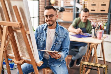 Two men artists smiling confident drawing at art studio