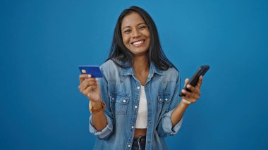 Akıllı telefon ve kredi kartıyla alışveriş yapan Afro-Amerikalı bir kadın.