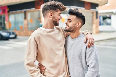 Young couple smiling confident hugging each other at street