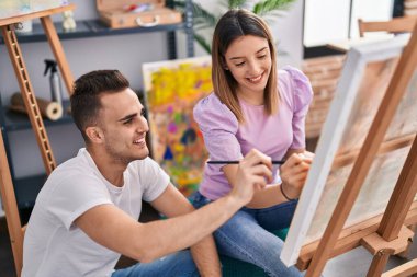 Man and woman artists couple smiling confident drawing at art studio clipart