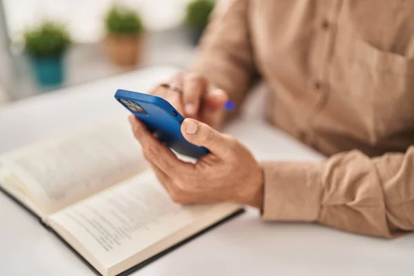 Ανώτερος Άνθρωπος Ανάγνωση Βιβλίο Χρησιμοποιώντας Smartphone Στο Σπίτι — Φωτογραφία Αρχείου