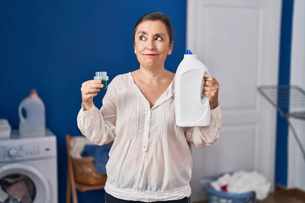 Middle Age Hispanic Woman Holding Detergent Bottle Smiling Looking Side — Stock Photo, Image