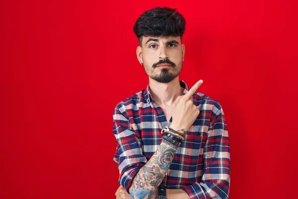 Ung Latinamerikansk Man Med Skägg Stående Över Röd Bakgrund Pekar — Stockfoto