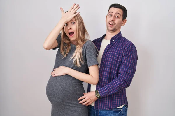 Casal Jovem Esperando Bebê Sobre Fundo Branco Surpreso Com Mão — Fotografia de Stock
