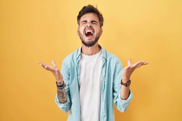 Young Hispanic Man Tattoos Standing Yellow Background Celebrating Mad Crazy — Stockfoto