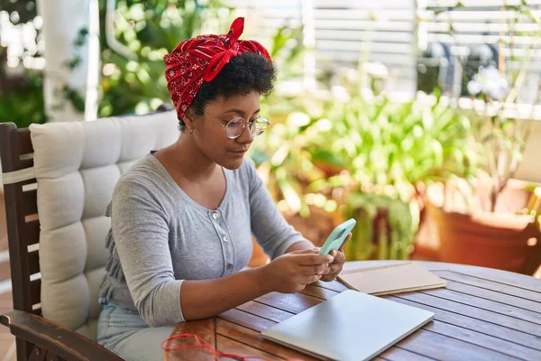 Mujer Afroamericana Usando Teléfono Inteligente Sentado Mesa Terraza Del Hogar —  Fotos de Stock