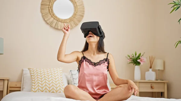 年轻美丽的惊慌失措的女人在卧室里用虚拟现实眼镜玩电子游戏 — 图库照片