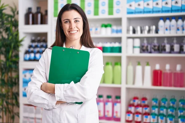 Jovem Bela Mulher Hispânica Farmacêutico Sorrindo Confiante Segurando Prancheta Farmácia — Fotografia de Stock