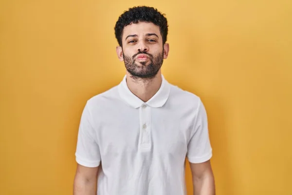 Homem Árabe Sobre Fundo Amarelo Olhando Para Câmera Soprando Beijo — Fotografia de Stock