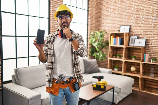 Ung Latinamerikan Man Med Skägg Arbetar Hemma Renovering Håller Smartphone — Stockfoto