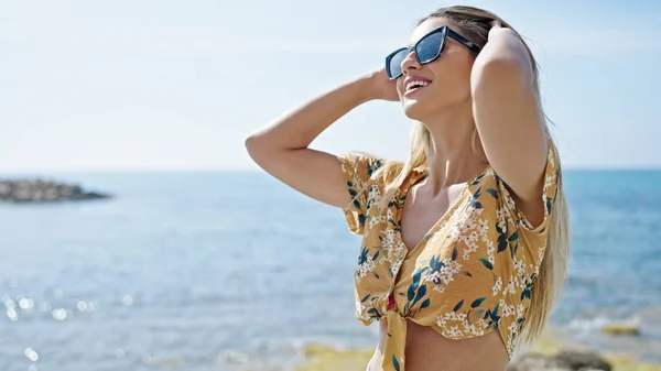 Joven Rubia Sonriendo Confiada Peinando Pelo Playa —  Fotos de Stock
