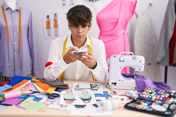 在裁缝店里 他的青少年小裁缝用智能手机给服装设计拍照 — 图库照片