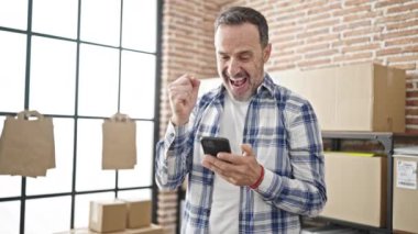 Orta yaşlı bir iş adamı ofisteki en iyi ifadeyle akıllı telefon kullanıyor.