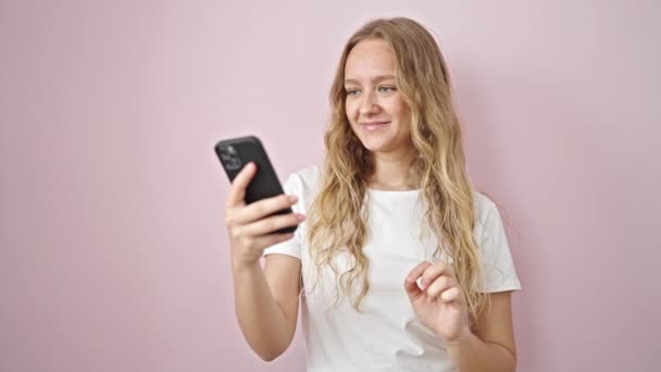 Ung Blond Kvinna Ler Säker Med Videosamtal Över Isolerade Rosa — Stockvideo